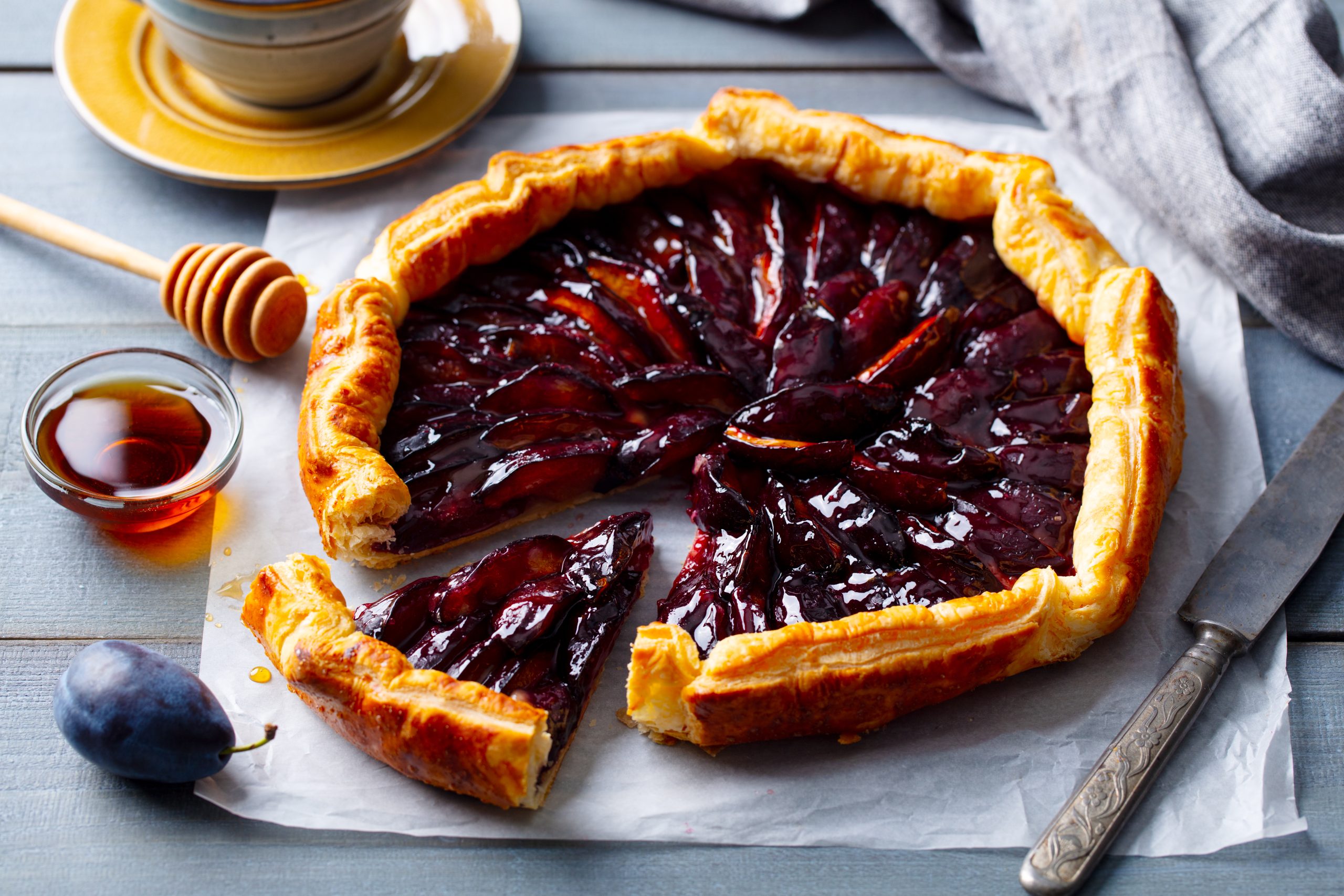 Plum,Galette,With,Cup,Of,Tea.,Grey,Wooden,Background.,Close